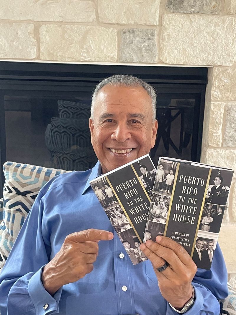 Jacob Lozada holding up copies of his book Puerto Rico to the White House