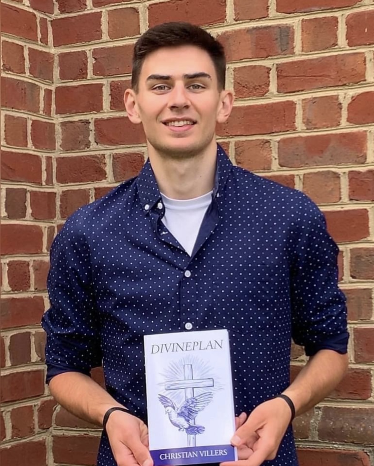 Author Christian Viller holding his book