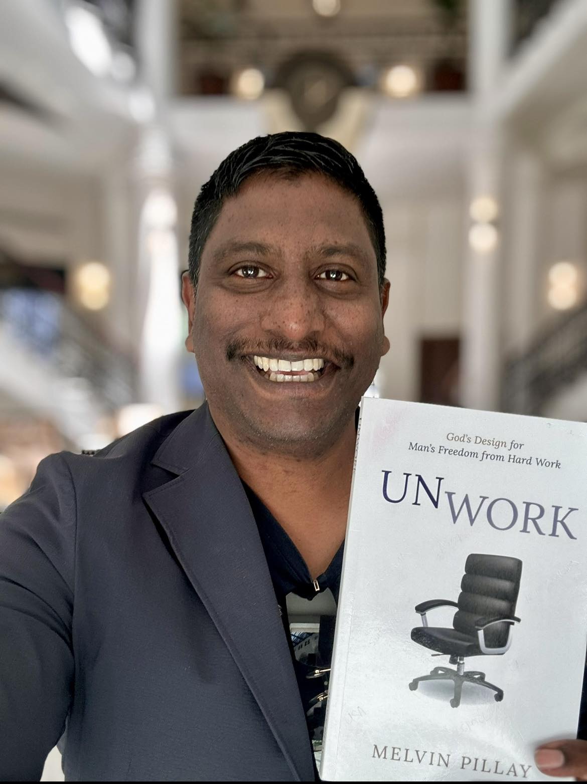 Author Melvin Pillay holding his book