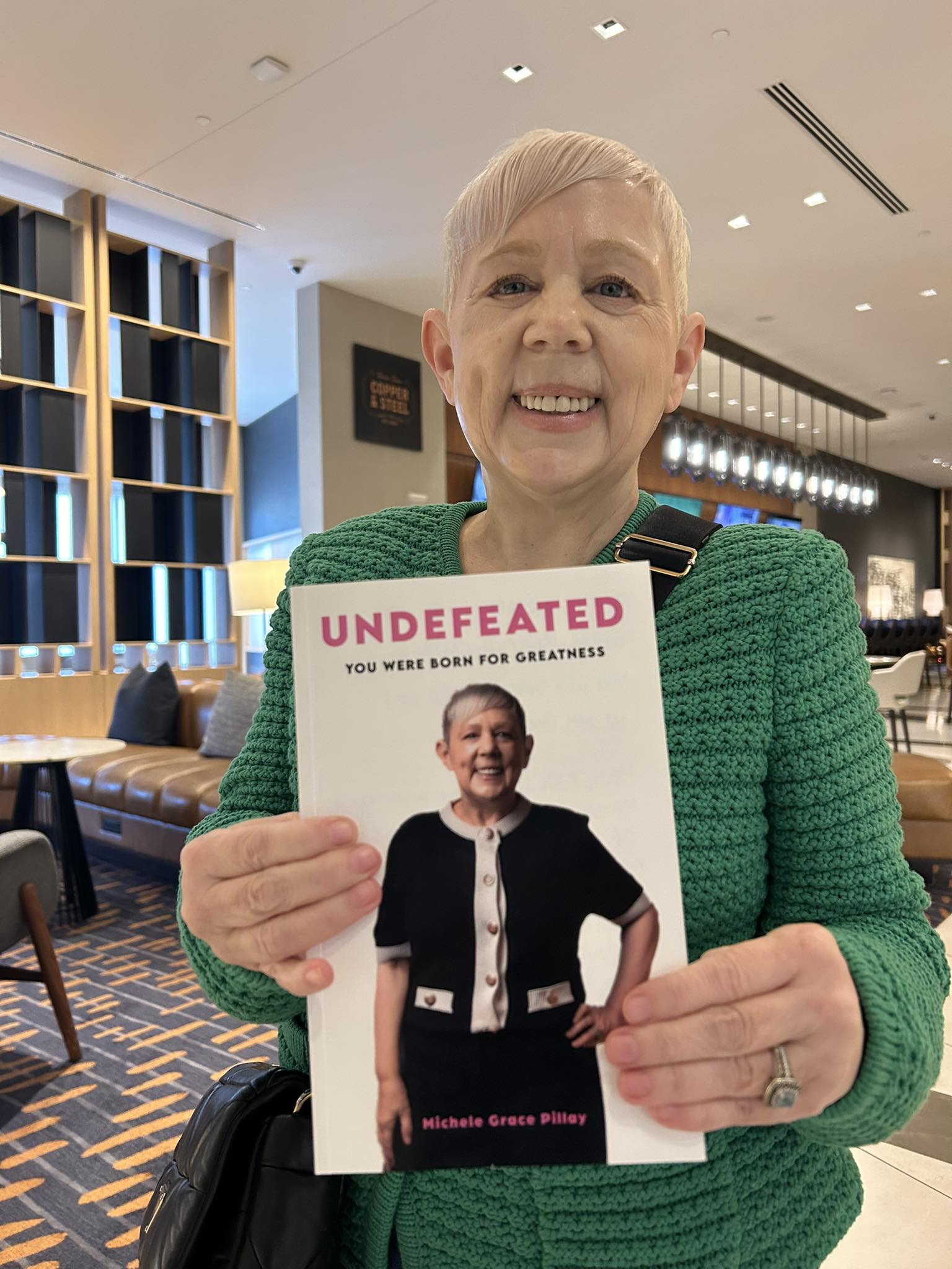 Author Michelle Pillay holding her book