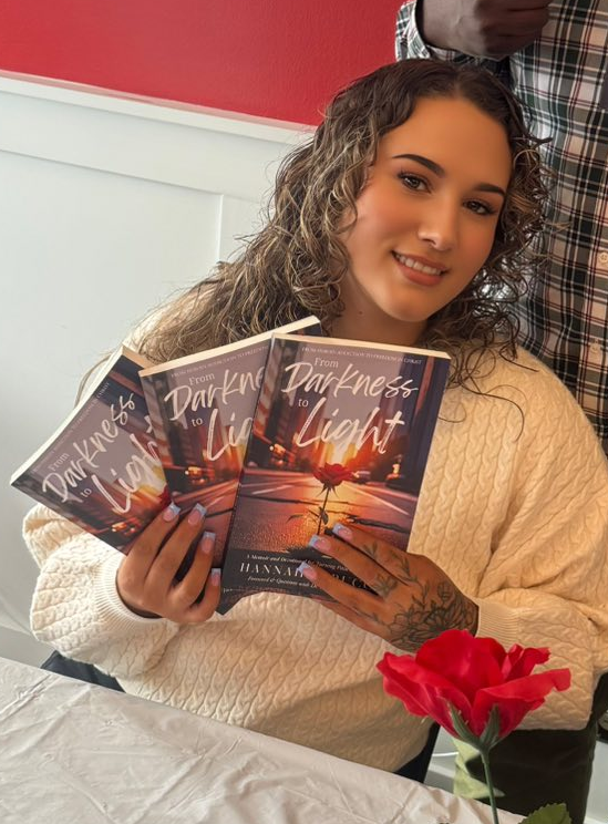 Author Hannah Larucci holding her book